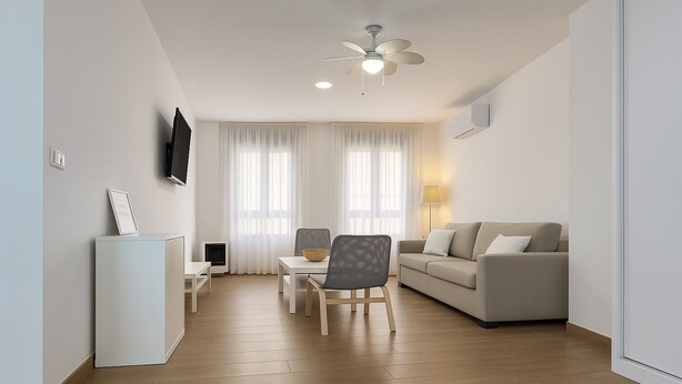 Una sala de estar moderna con un sofá, una mesa de comedor con sillas, un televisor montado en la pared y un ventilador de techo.