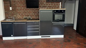 A compact kitchen with a built-in oven, a microwave, and a sink.