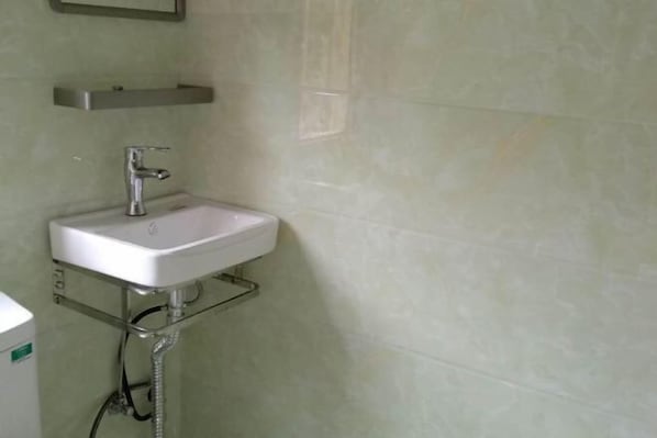 A bathroom with a white sink, a chrome faucet, and a chrome shelf above it. - Qingyuan Yinxing Farm Stay (Wuyuan)