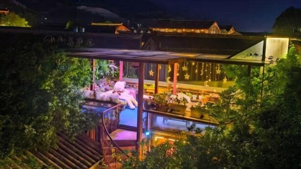 A traditional building with a pool, outdoor seating, and a covered area. - Gudao Gudao Renjia Inn (Lijiang)