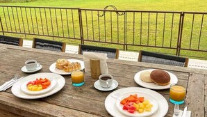 Una mesa de madera dispuesta con alimentos para el desayuno y una vista panorámica.