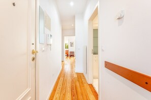 Enter a serene space with a door leading to a room featuring a light-colored floor and a wooden bench.