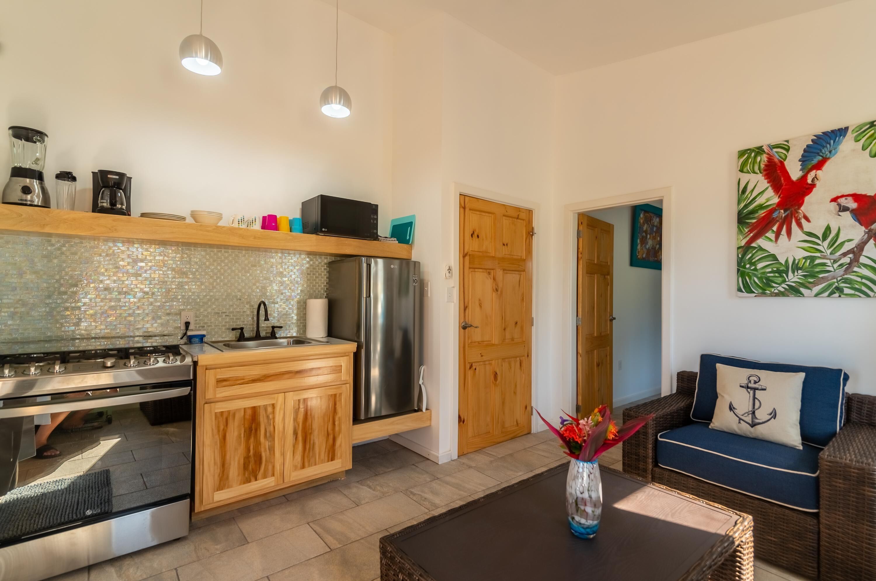 A modern kitchen with a stainless steel refrigerator, wooden cabinets, and a tiled backsplash.