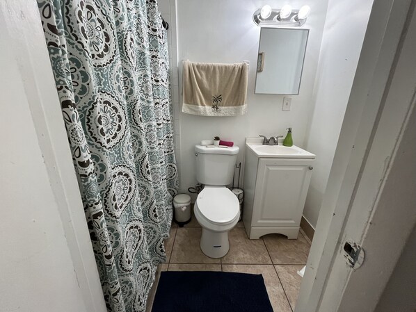 A small bathroom with a toilet, sink, and mirror.