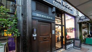 Un salon de coiffure appelé « Bourne House », avec un numéro de téléphone et une enseigne indiquant que les coupes pour hommes sont proposées à 15 livres sterling.