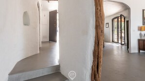 A spacious interior with white walls, a wooden beam, and a door leading to another room. - Spectacular Seaview Escape (Quartu Sant'Elena)