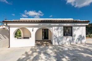 A white building with a tiled roof, two arched windows, and a door. - Spectacular Seaview Escape (Quartu Sant'Elena)
