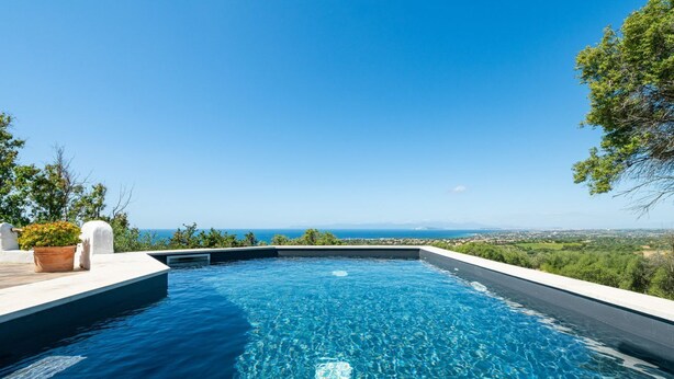 A rectangular infinity pool with clear blue water, surrounded by a white deck. - Spectacular Seaview Escape (Quartu Sant'Elena)