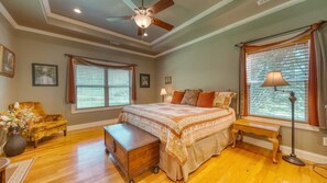 A bedroom with a bed, a wooden chest, a chair, a lamp, and a window with blinds. - Country Lane - Creek Front (Hiawassee)