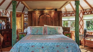 Un dormitorio amplio con una cama grande, cabecero de madera y dosel.