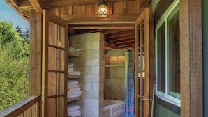 Una cabaña de madera con baño que incluye bañera y ducha.