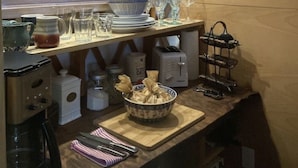 Una cocina con encimera de madera, cafetera, tostadora y un cuenco decorativo.