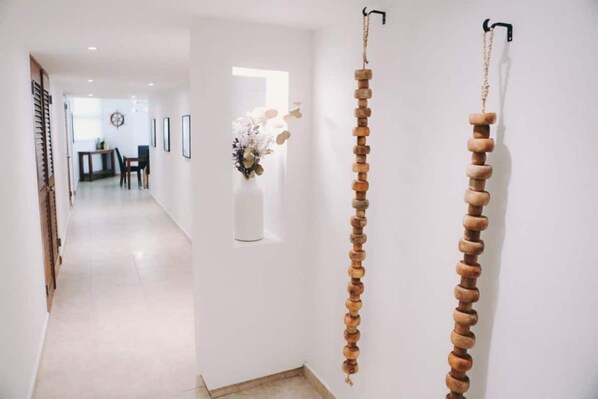 Un pasillo con un tapiz de madera y un jarrón con flores.