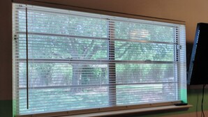 A window with horizontal blinds, a visible tree outside, and a monitor to the right. - Comanche, Cameron,  Good Year, Fort-Sill, Medicine Park, Lawton, Oklahoma. 
 (Lawton)