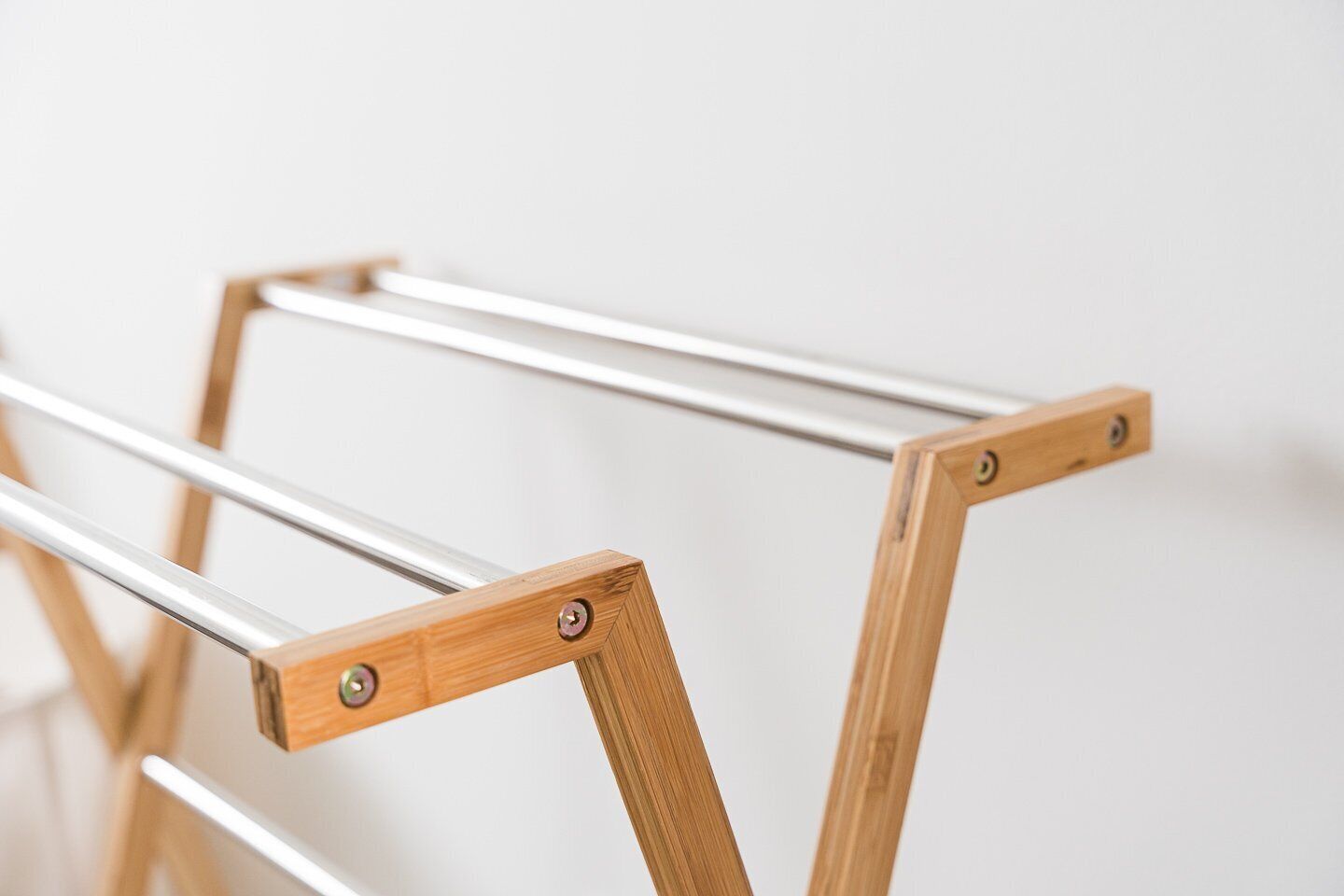 A wooden drying rack with metal rods.