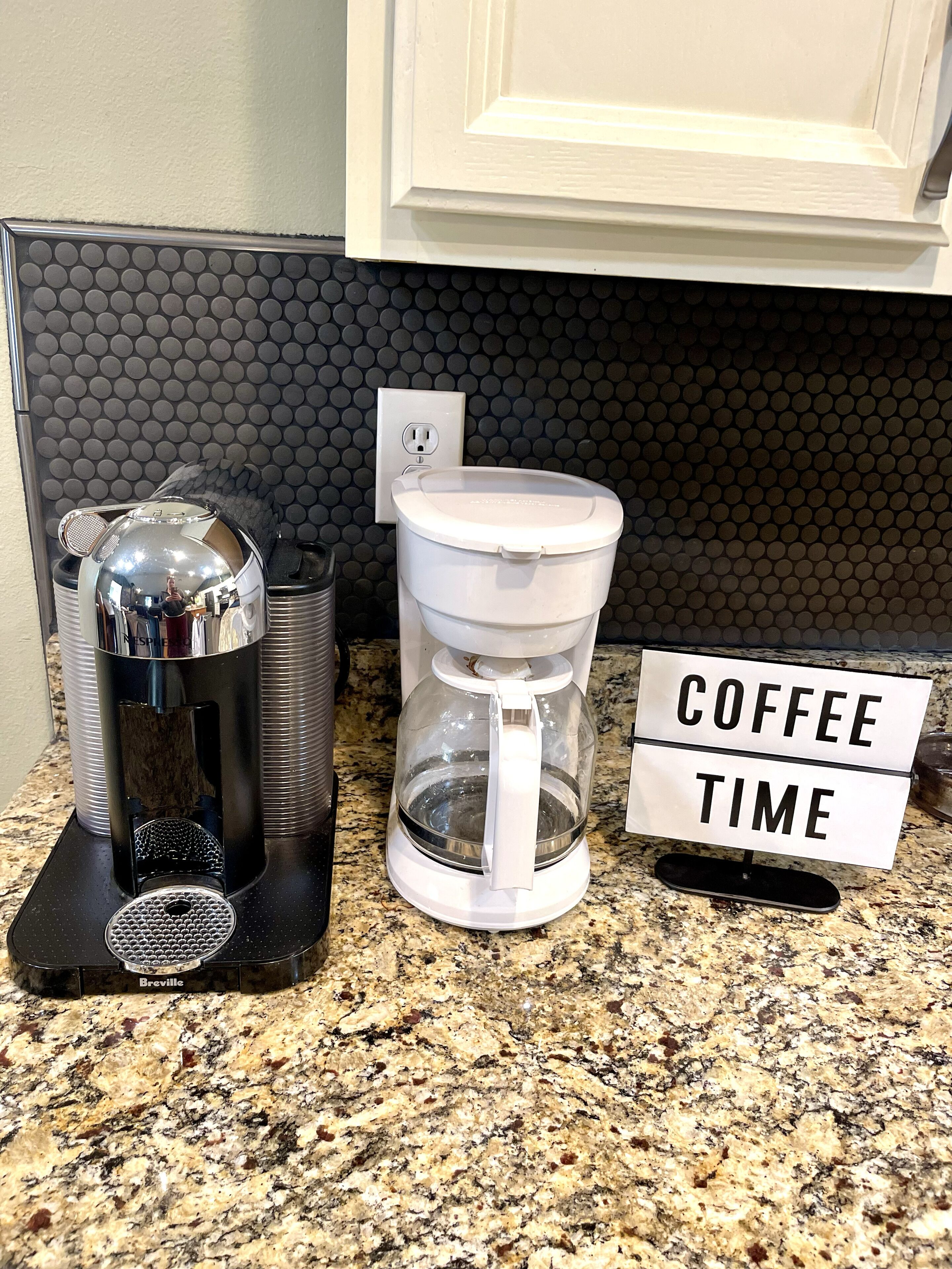 A coffee maker, a glass carafe, and a sign that reads 'COFFEE TIME' on a kitchen counter.