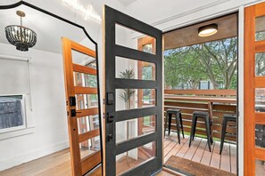 Un interior moderno con una puerta de madera que da a un patio exterior.