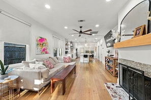 A spacious living room with a sofa, coffee table, and fireplace.