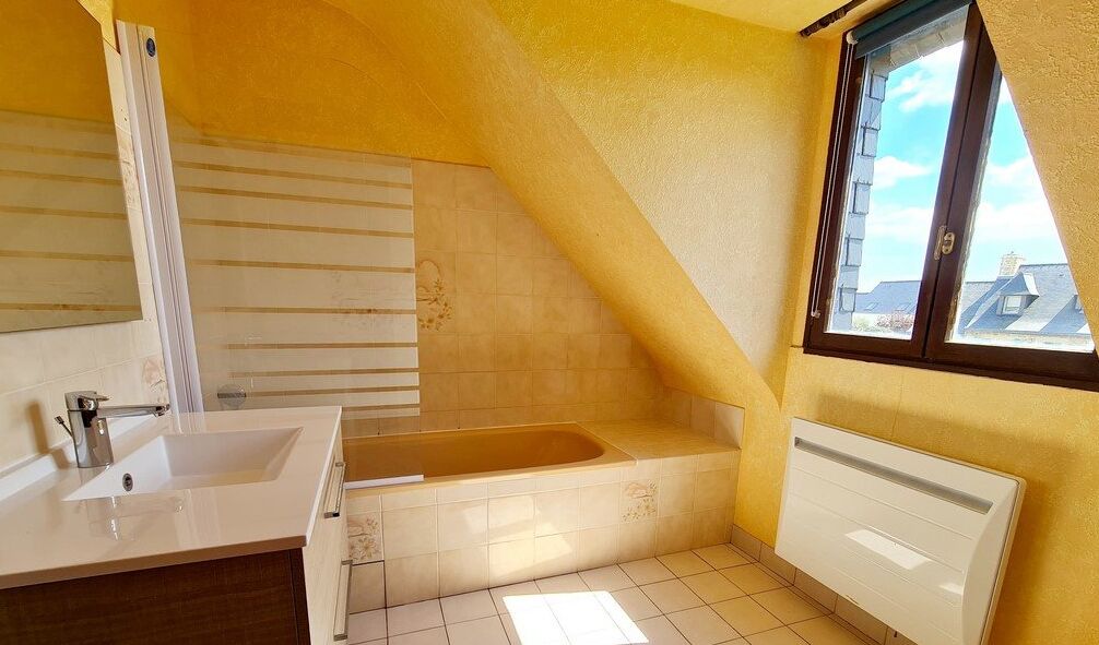 A bathroom with a bathtub, a sink, and a window with a view of buildings.