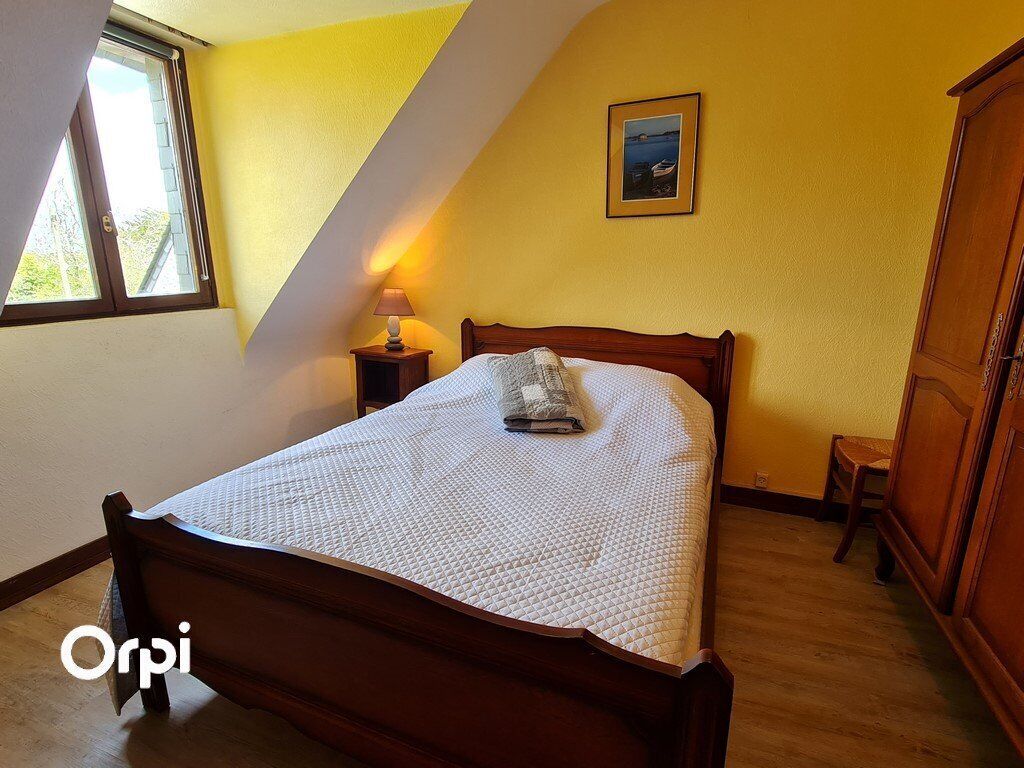 Un dormitorio con una cama de madera, una mesita de noche, una silla y un armario.