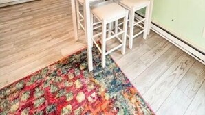 A compact kitchen with white cabinets, a built-in oven, and a small dining area with two stools. - Love Shack Private Hot tub  steps to Jet/Town (Port Clinton)