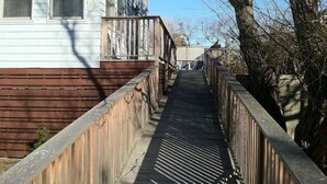 Un étroit sentier en bois mène à un bâtiment portant le numéro « 449 ».