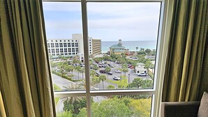 A room with a large window overlooking a parking lot and a building with a dome. - Luau 6533 South Facing Gulf Views! |Wifi | Tram Included (Miramar Beach)