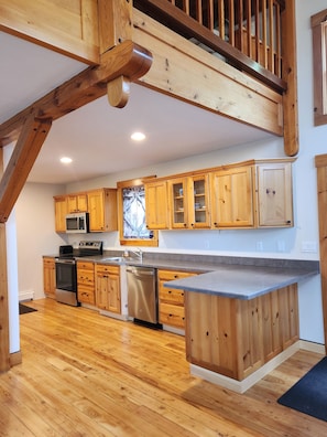A kitchen with wooden cabinets, a stainless steel dishwasher, and a microwave.