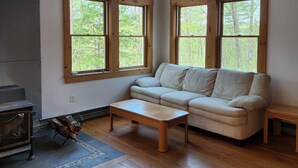 Una sala de estar con sofá, mesa de centro y chimenea.