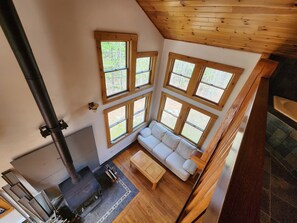 A cozy room with a fireplace, a sofa, and large windows.