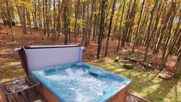A hot tub on a wooden deck surrounded by a forest. - Bear Lair 1 Pet friendly,walking trails,hot tub (Albrightsville)