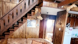 A wooden interior with a large sectional sofa, a staircase, and a kitchen area. - Bear Lair 1 Pet friendly,walking trails,hot tub (Albrightsville)