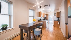 Una cocina moderna con armarios de madera, una isla central y taburetes de bar.