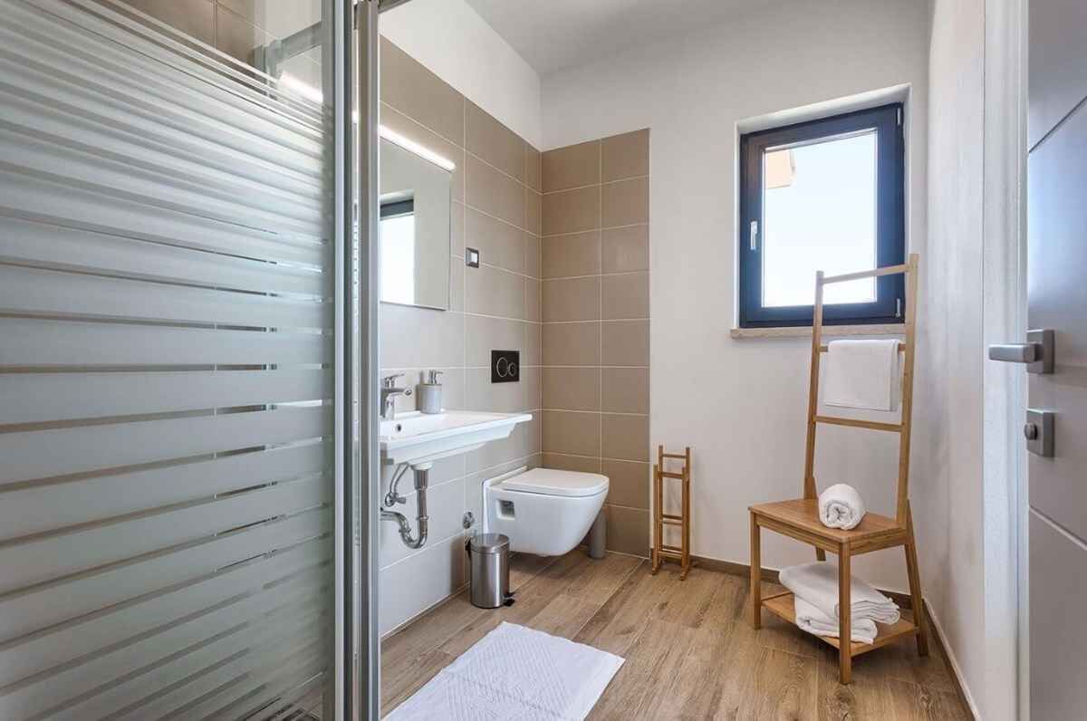 Une salle de bain moderne avec des toilettes, un lavabo et une fenêtre.