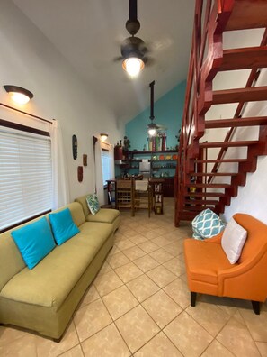 Cozy living space with a sofa, armchair, and dining table.