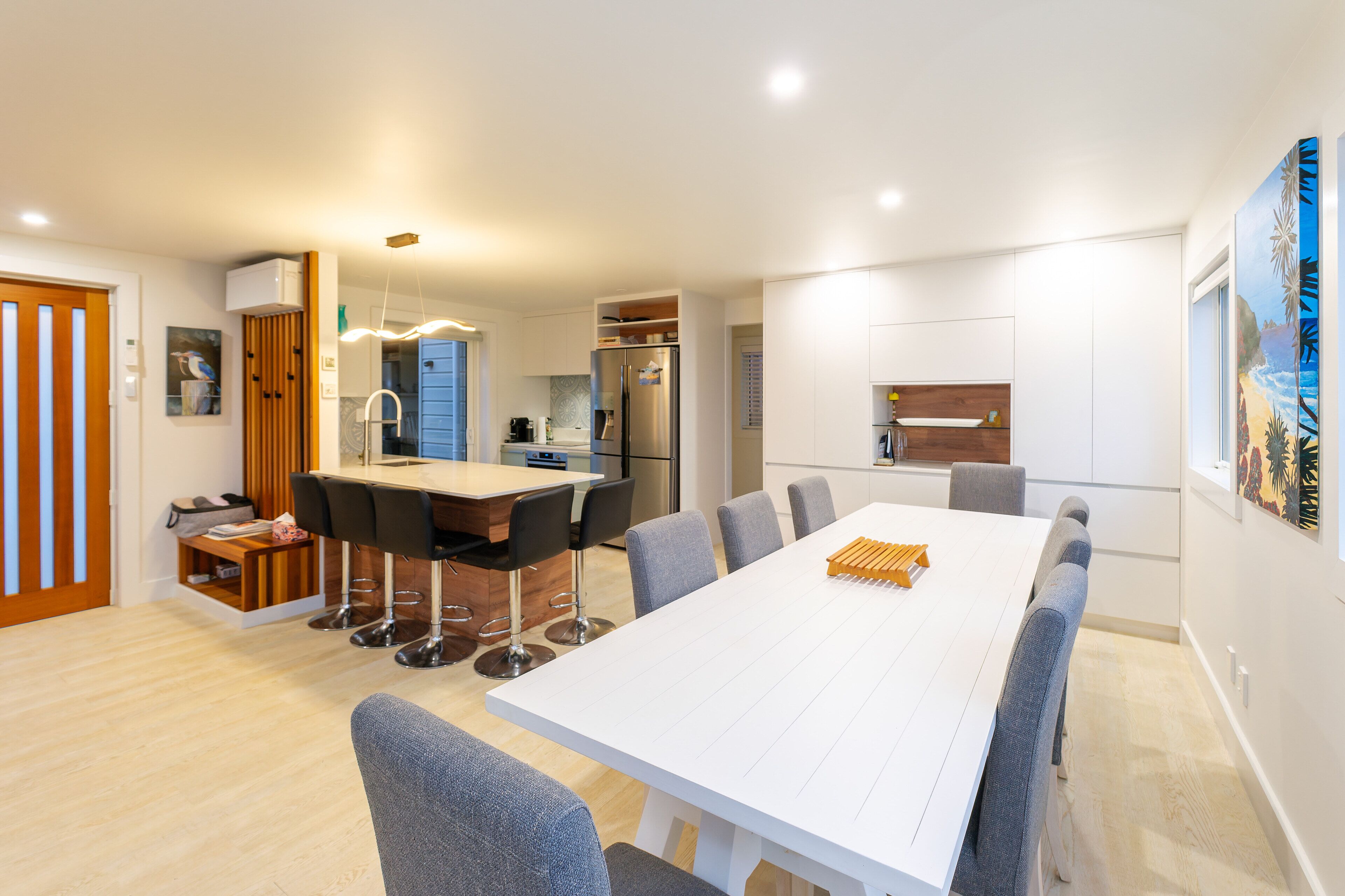 A modern kitchen with white cabinets, a built-in oven, and a refrigerator.
