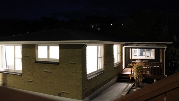 A two-story house with a visible front porch and a small garden. - Orchard Leigh on the Quarry (Dunedin)