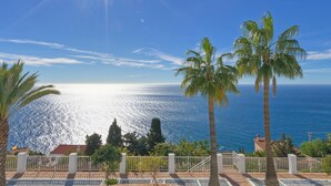A coastal view with palm trees, a clear sky, and a bright sun. - Luxury villa, breathtaking views and heated pool (Salobreña)