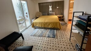 A modern bedroom with a large bed, a bench, a wardrobe, and a view of the outdoors. - Au Riad Des Deux Patios - Marrakech  (Marrakech)
