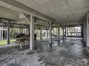An outdoor covered area with concrete pillars, picnic tables, and a grill. - Recently Renovated Canal Home in OIB bring your boat or just float ! (Ocean Isle Beach)