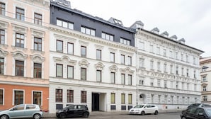 A row of multi-story buildings with classic architectural details, including ornate window frames and decorative moldings. - Premium Hernals 1BR w/ Balcony, nr Lidlpark, by Blueground (Vienna)