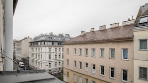 A row of multi-story buildings with uniform window patterns and a flat roof. - Premium Hernals 1BR w/ Balcony, nr Lidlpark, by Blueground (Vienna)