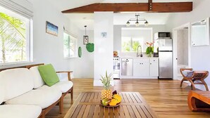 A modern kitchen with white cabinets, a microwave, and a sink. - Two homes on the ocean with a private saltwater pool.  (Keaau)