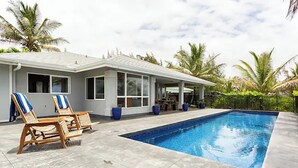 A modern house with a swimming pool, two lounge chairs, and a covered patio area. - Two homes on the ocean with a private saltwater pool.  (Keaau)