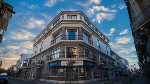 A corner building with multiple floors, featuring storefronts on the ground level with signage for Samsung. - HOTEL DE SOL (Tarija)