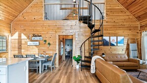 Eine geräumige Holzhütte mit Küche, Essbereich und Wohnzimmer.