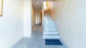 Een modern interieur met een trap die leidt naar een overloop.