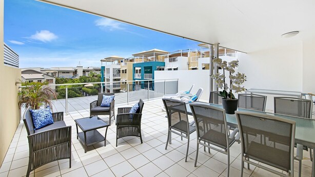 A rooftop terrace with outdoor furniture, a glass table, and a potted plant. - Central Coolum Penthouse with Rooftop Terrace (Coolum Beach)