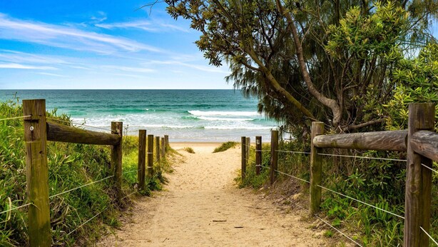 A sandy beach path leading to the ocean, surrounded by greenery and wooden fences. - Unit 2 'Marcoola Sands' (Marcoola)