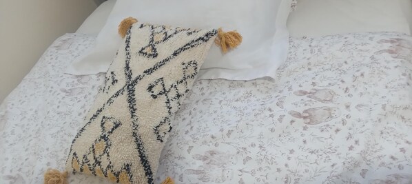 A bed with a floral-patterned bedspread and a decorative throw blanket with tassels. - Charming 2-Bed Apartment in London (London)